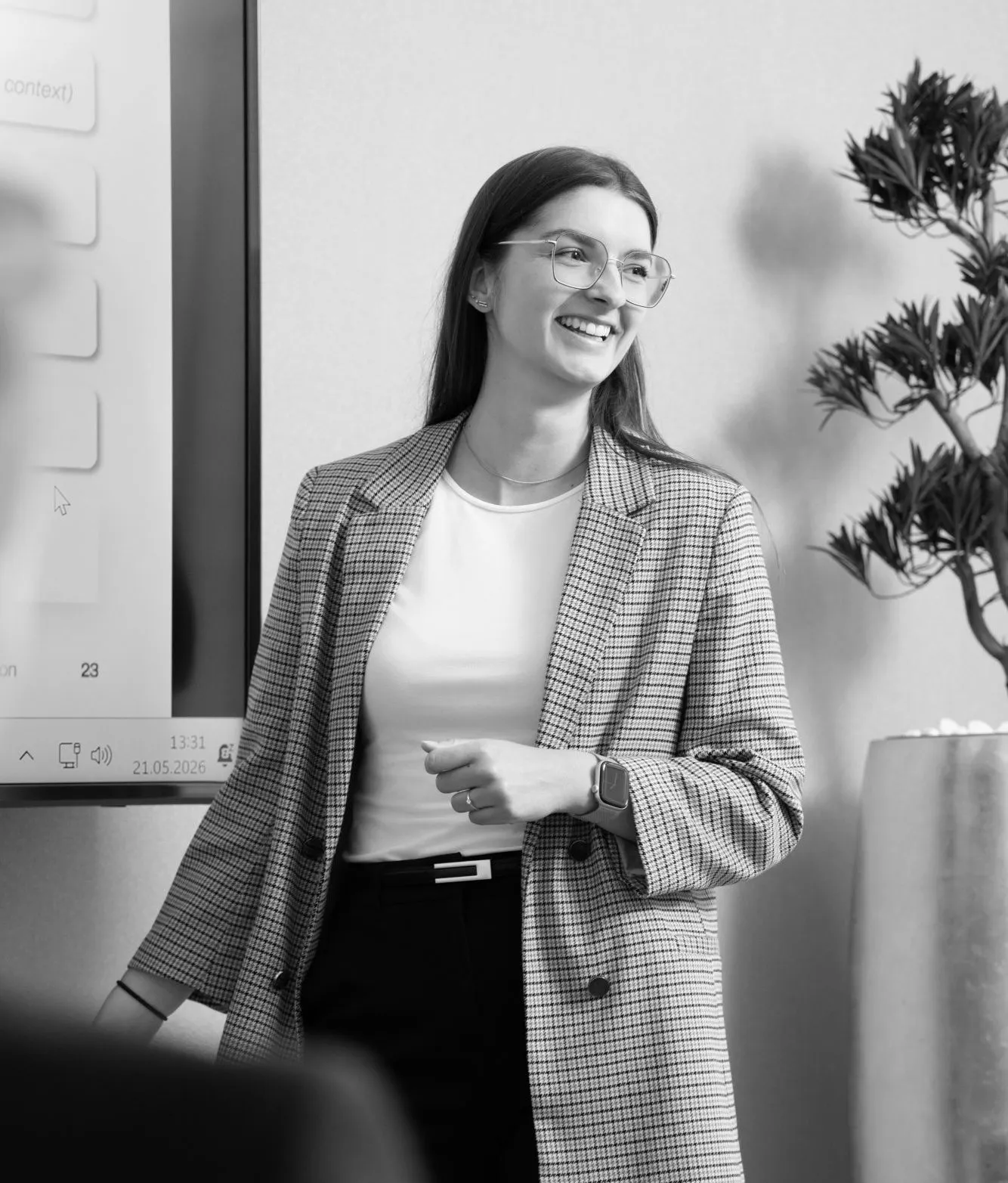 A young woman smiling at her audience during a presentation.